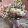 Bouquet of white and blush flowers wrapped in pink paper