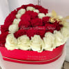 Red and white roses arranged in a heart-shaped box with a butterfly decoration