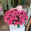 An ultra-lush basket overflowing with premium hot pink spray roses, designed in