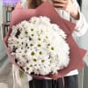 A voluminous bouquet of fresh white chrysanthemums, arranged in a perfectly rounded