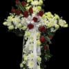 Cross-shaped floral spray with red roses, white chrysanthemums, and white ribbon