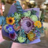Mixed bouquet with colorful flowers wrapped in purple paper