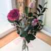 Pink roses in a clear glass vase with airy filler flowers