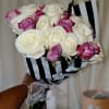 Bouquet of white and pink roses wrapped in black-and-white striped paper