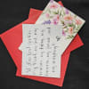 Red envelope with a floral card and handwritten note
