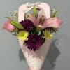 A big pink lily takes center stage in this cheerful hand-tied flower