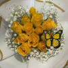 A cluster of sunlit yellow roses takes center stage in this cheerful