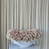 A cloud of pale blush and cream roses arranged as a low