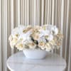 A low, luminous cluster of cream and white roses topped with large
