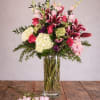 Tall bouquet of pink lilies, roses, and hydrangeas in a glass vase