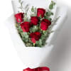 Bouquet of red roses wrapped in white paper with a red ribbon