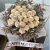 Bouquet of pale pink roses with metallic bronze foliage and a pink ribbon