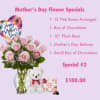 Pink roses in a glass vase with a heart balloon, teddy bear, and chocolates
