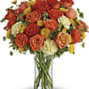 Bouquet of orange and red roses in a clear glass vase