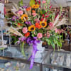 colorful display of sunflowers and wheat in a beautiful urn