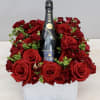 Red roses arranged around a Moët & Chandon champagne bottle in a white box