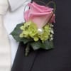 A full sized rose boutonnieres in a cloud of light green accent.
