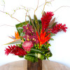 Tropical flower arrangement with red and orange blooms in a wooden vase