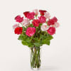 Bouquet of pink, red, and white roses in a clear glass vase