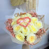 A rounded bouquet of pale yellow roses gathered tightly into a heart-forward