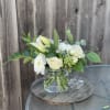White flowers and pale yellow lilies in a clear glass vase