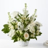 White floral arrangement in a white basket with a pale rose accent