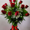 Bouquet of red roses with baby's breath in a glass vase