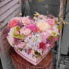 Heart-shaped box filled with pink and white roses and mixed flowers