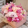 Pink and peach floral arrangement in a heart-shaped box