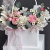 Soft pink roses and pale carnations mingle with white alstroemeria and dainty