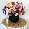 Pink and purple bouquet in a black vase with a ribbon