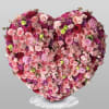 Heart-shaped arrangement of pink and red roses on a marble stand