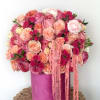 Pink and peach rose bouquet in a magenta hat box with trailing ribbons