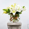 White lilies arranged in a clear glass vase