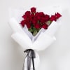 Bouquet of red roses wrapped in white paper with a black ribbon
