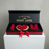 Black gift box with red roses and a red ribbon bow