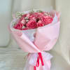 Pink rose bouquet wrapped in pale pink paper with a ribbon