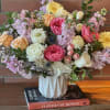 Mixed bouquet of pastel roses, gerbera daisies, and stock in a white vase