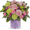 Pink roses and mixed flowers arranged in a purple vase