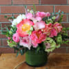 Pink and white mixed bouquet in a green glass vase