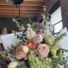 Soft blush garden roses and pale green hydrangeas mingle with delicate white