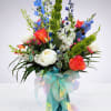 A vibrant ocean-inspired arrangement featuring crisp white blooms, bright coral roses, and