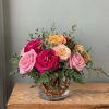 A bright, rounded cluster of mixed roses makes a joyful centerpiece that