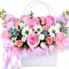 Rounded clusters of pink roses and ruffled carnations create a soft, romantic