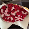 Large bouquet of red and pale pink roses wrapped in white paper