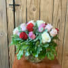 A lush rounded cluster of red, blush pink, and white roses creates