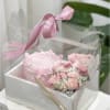 A petite pink cake paired with a compact cluster of blush roses