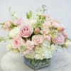 Blush pink and white bouquet in a square glass vase