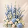 An elegant garden-style floral arrangement designed with soft blue hydrangeas, premium ivory