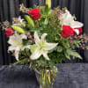 Bouquet of red roses and white lilies in a clear glass vase